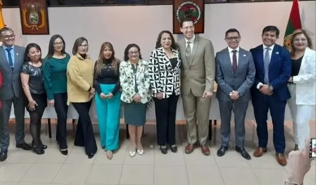 Ponentes, organizadores y asistentes posan en el auditorio del Colegio con los emblemas institucionales al fondo