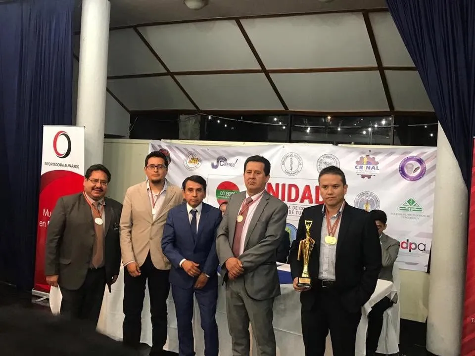 Deportistas abogados posan con medallas y trofeo en la clausura de los Juegos Deportivos Interprofesionales